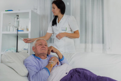 nurse checking dextrose of elderly man