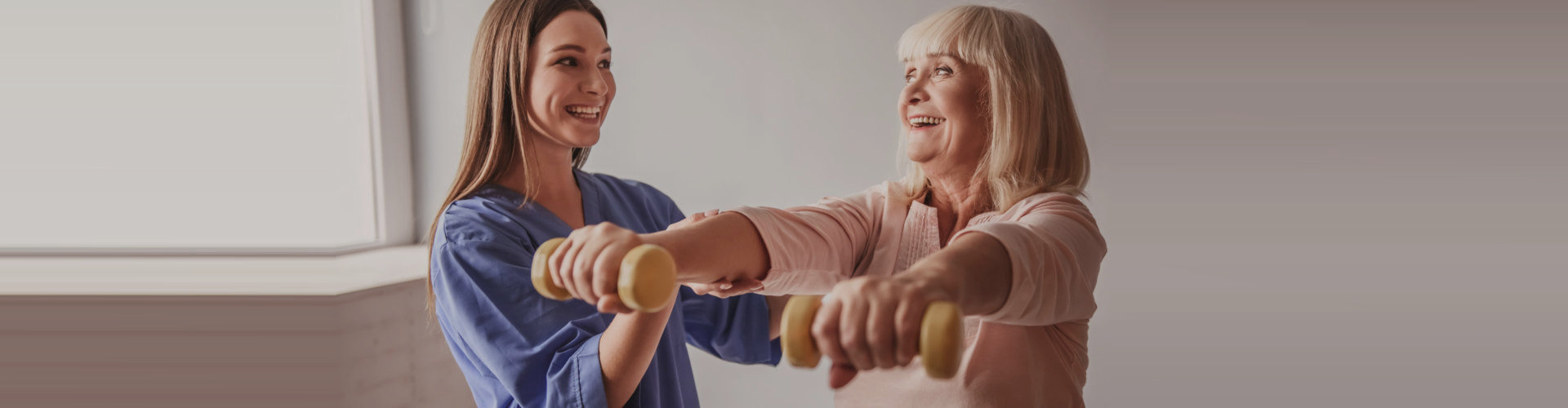 lady nurse assisting woman with her exercise